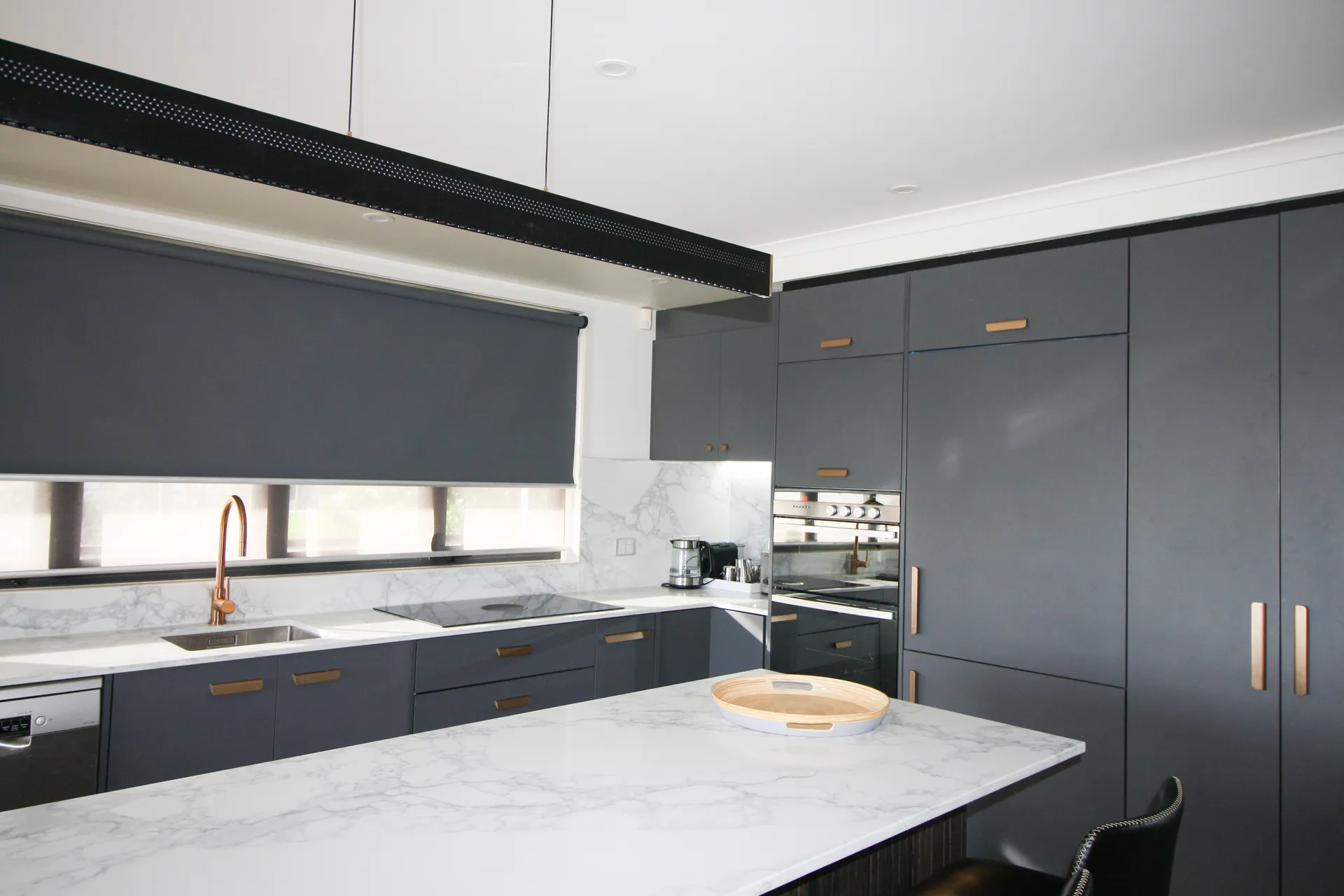 Charcoal back run and tall cabinets seen over the island benchtop