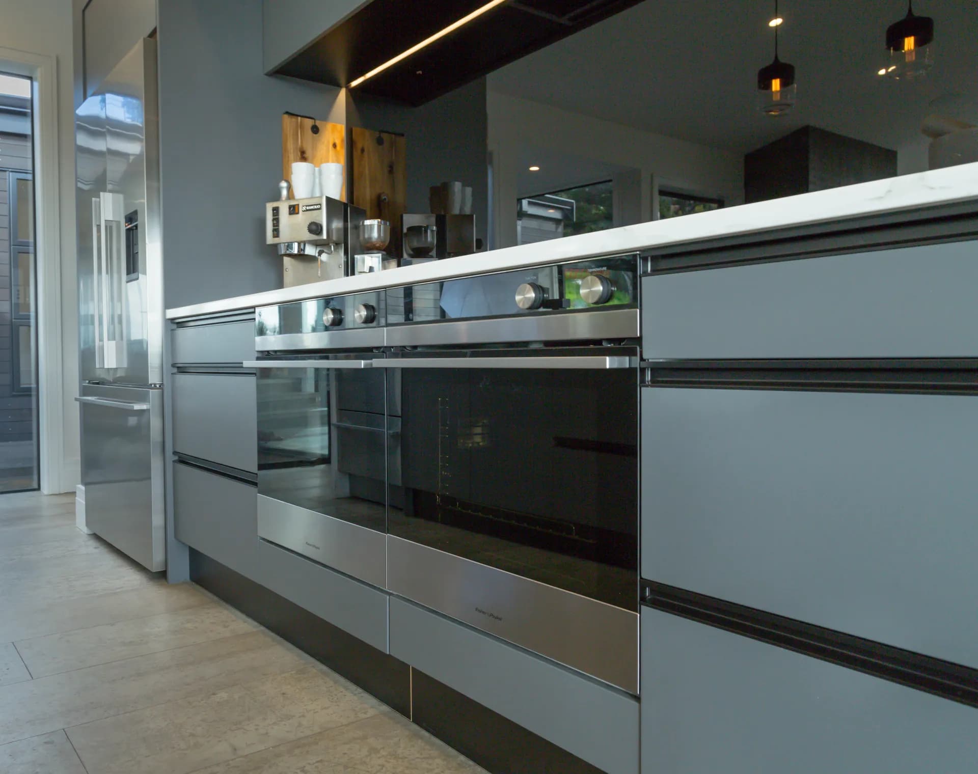 Low view along grey handleless drawers and wall ovens