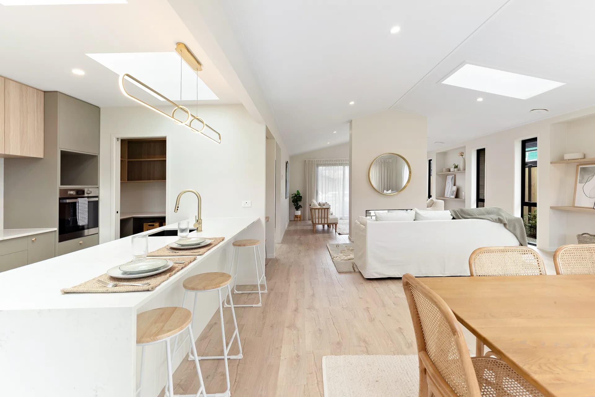 Island with stools looking toward the living area under a skylight