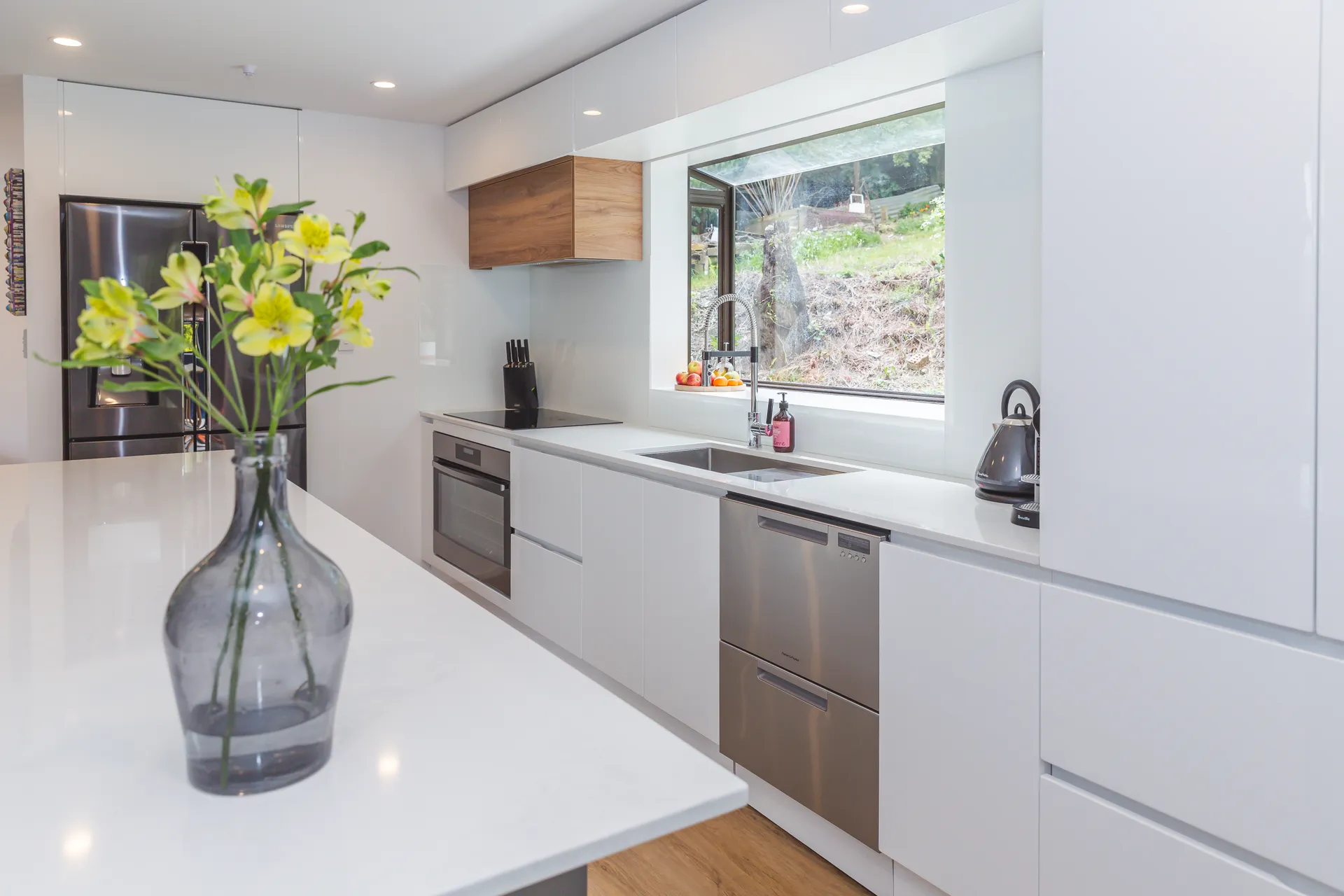 White gloss run with handleless drawers beside the window