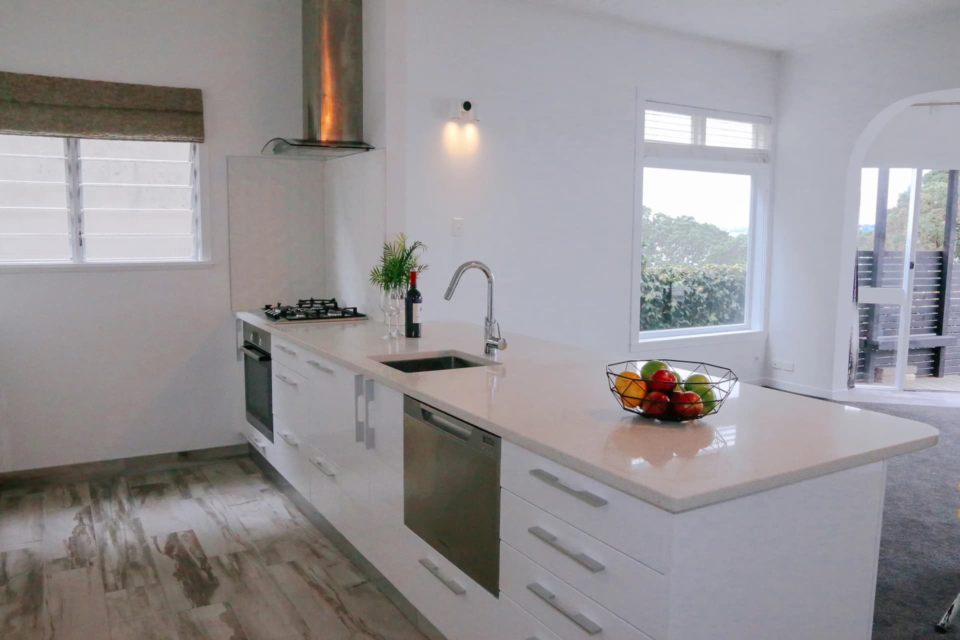 White gloss kitchen with bar handles and a peninsula seen as a whole