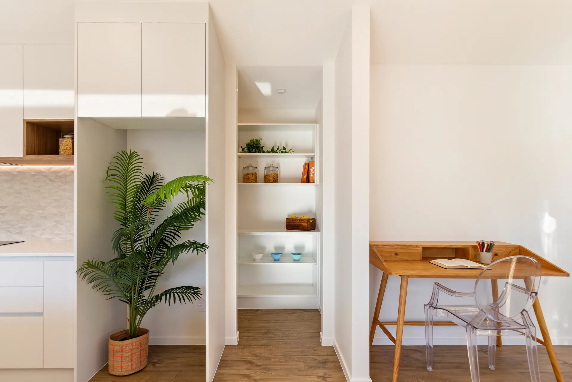 Pantry nook with open shelving beside a desk area