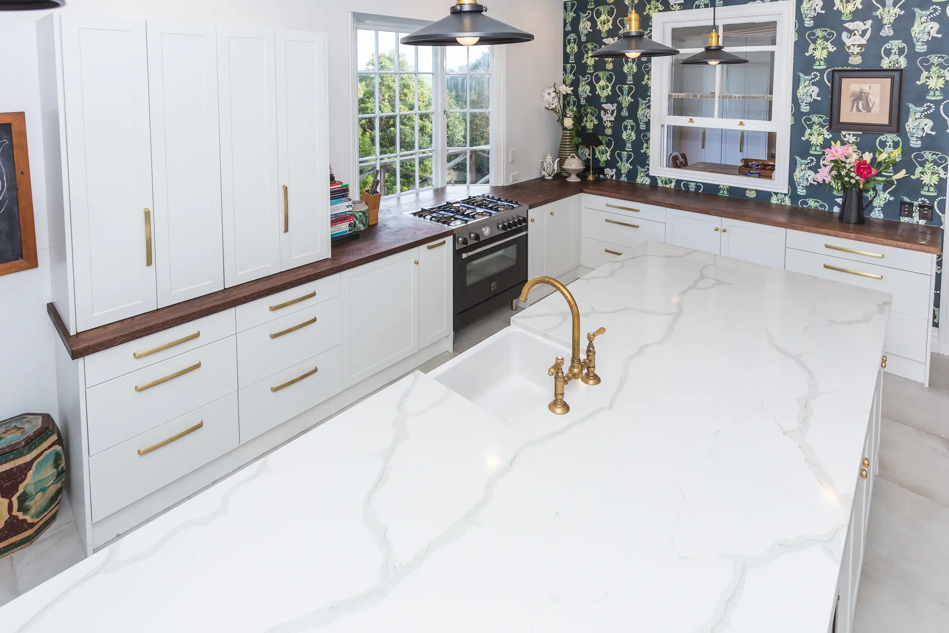 High view over the island to white shaker cabinets with gold-look handles
