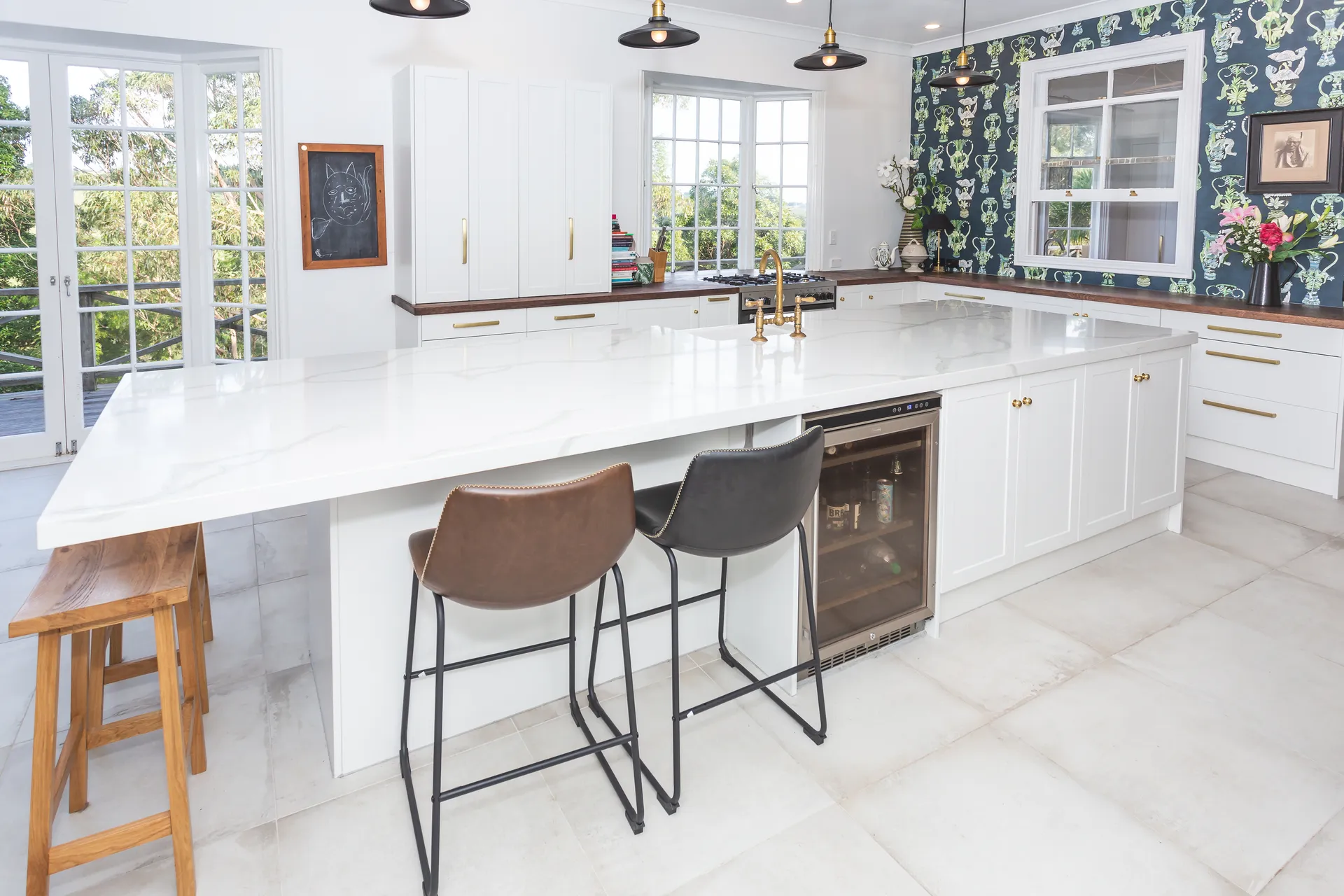 White shaker island with bar stools and a wine fridge