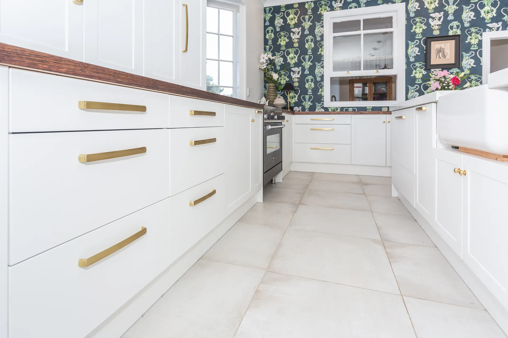 White shaker drawers with gold-look bar handles leading into the U-shaped run