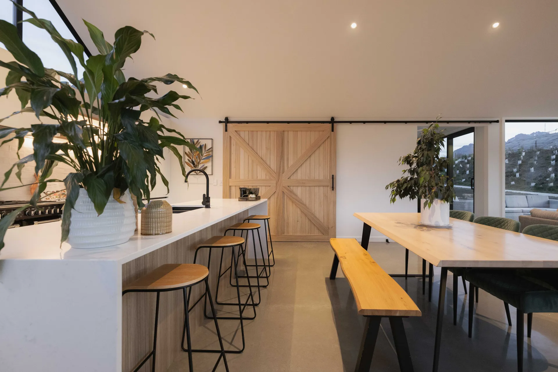 Island with stools beside the dining table and a timber-look barn door