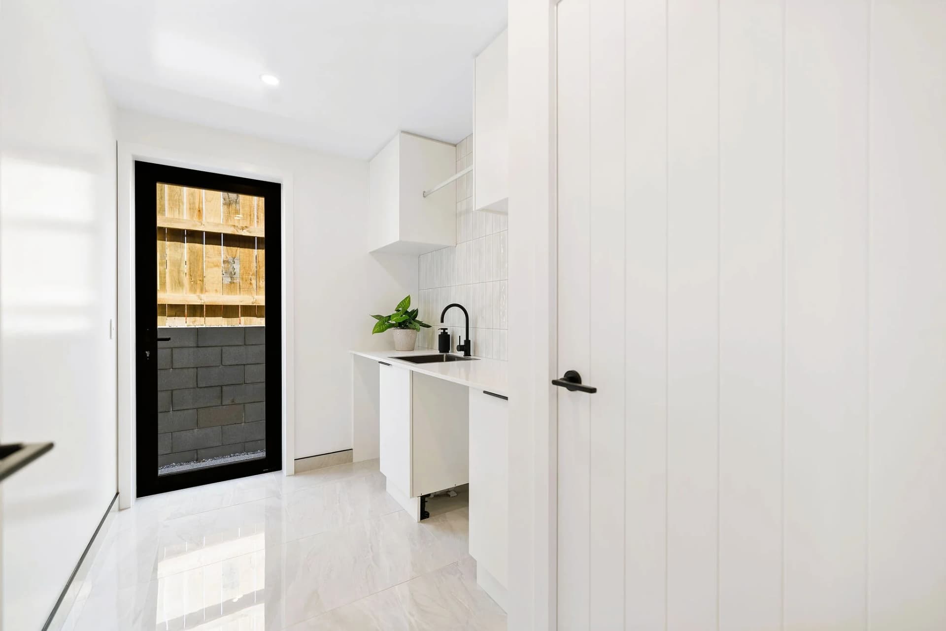 Custom laundry with overhead cabinetry and integrated washing machine, New Zealand