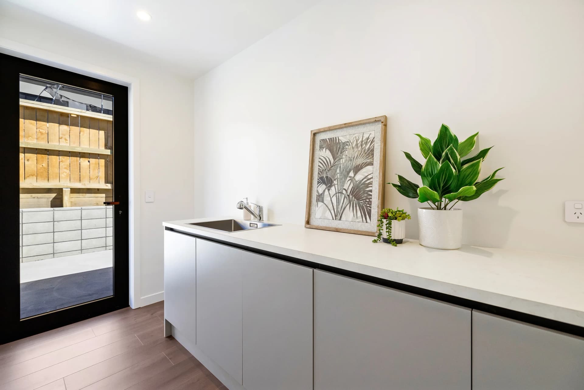 Modern laundry room with stone benchtop and handleless doors, Inspire Kitchens NZ