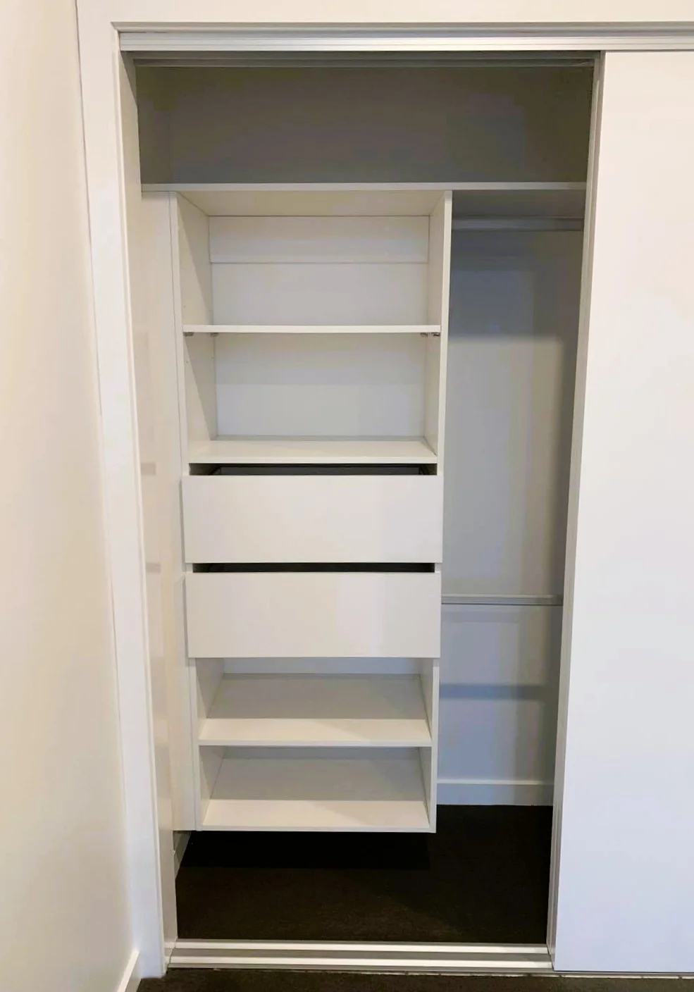 Modern walk-in wardrobe with island dresser and full-height shelving, Inspire Kitchens NZ