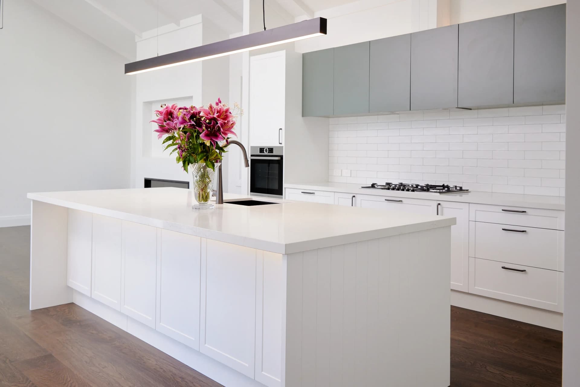 Two-tone kitchen with white uppers and dark grey lower cabinets, New Zealand home